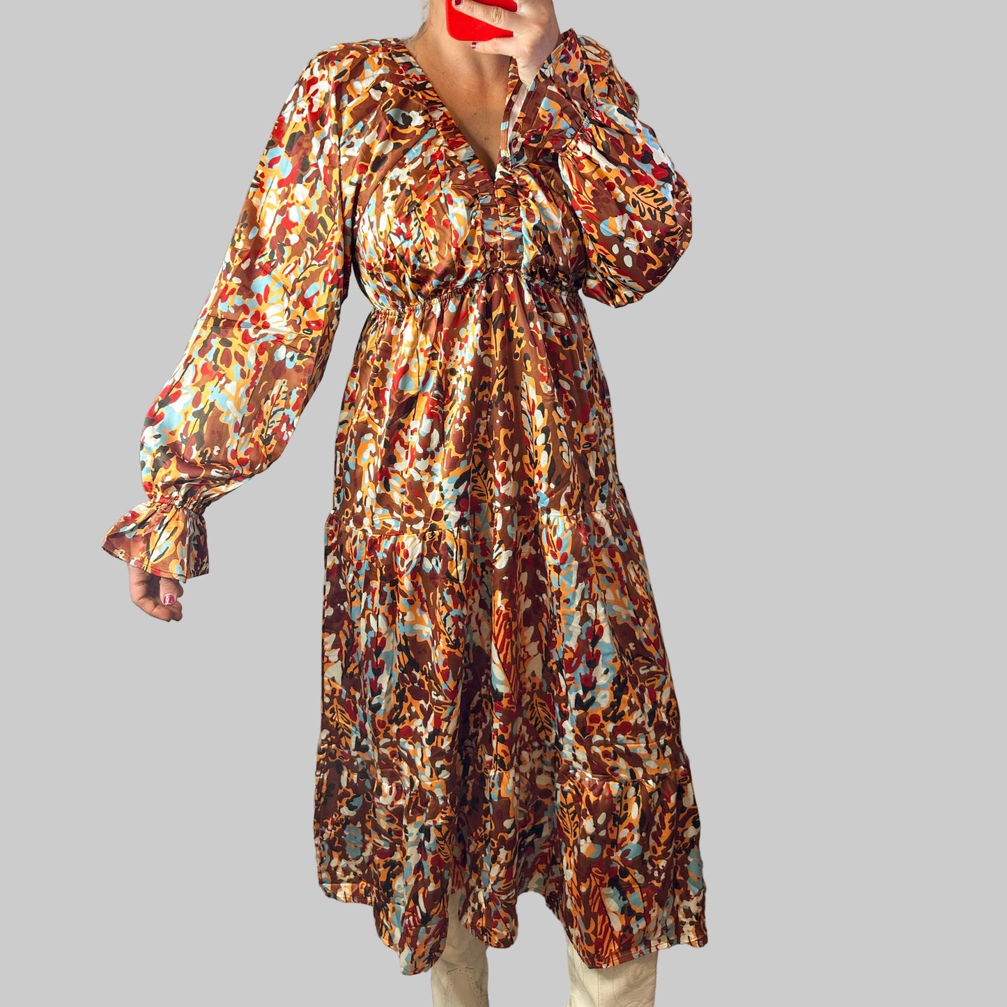 Person wearing a patterned dress standing on a rug indoors.