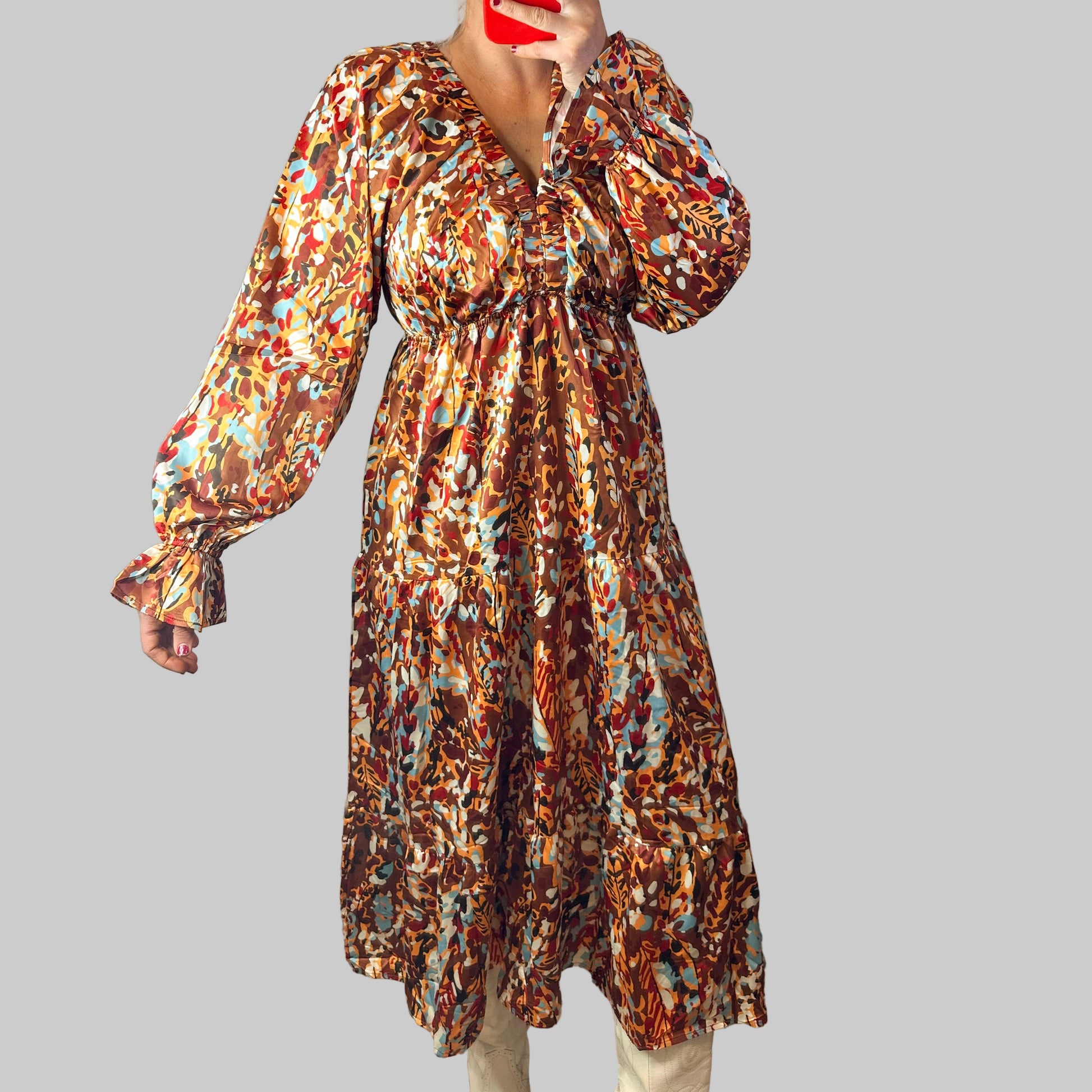 Person wearing a patterned dress standing on a rug indoors.